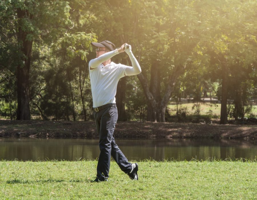 A golfer is driving golf in a golf court.